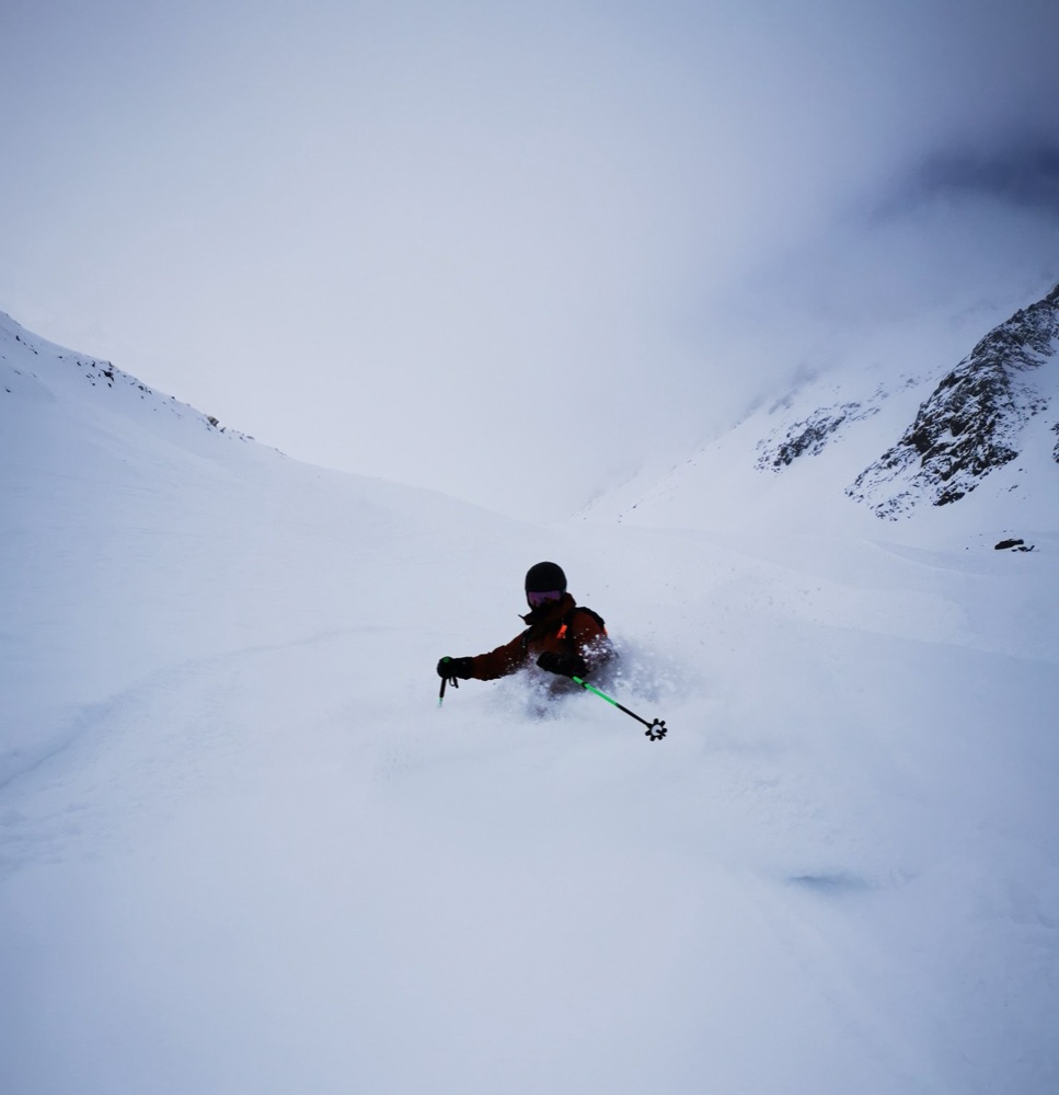 Skiing deep powder in a steep alpine bowl