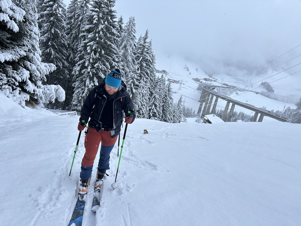 Ski touring uphill through snow-laden spruce forest